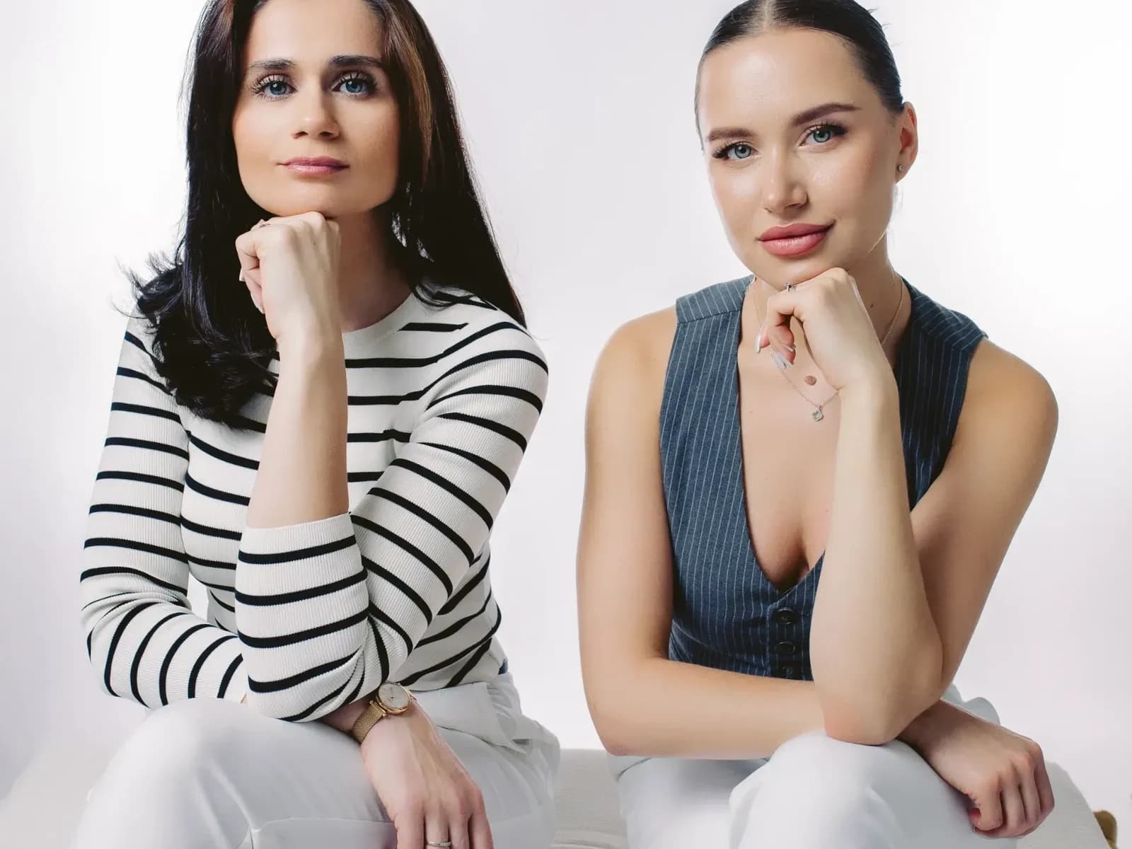two woman sitting and looking at the camera